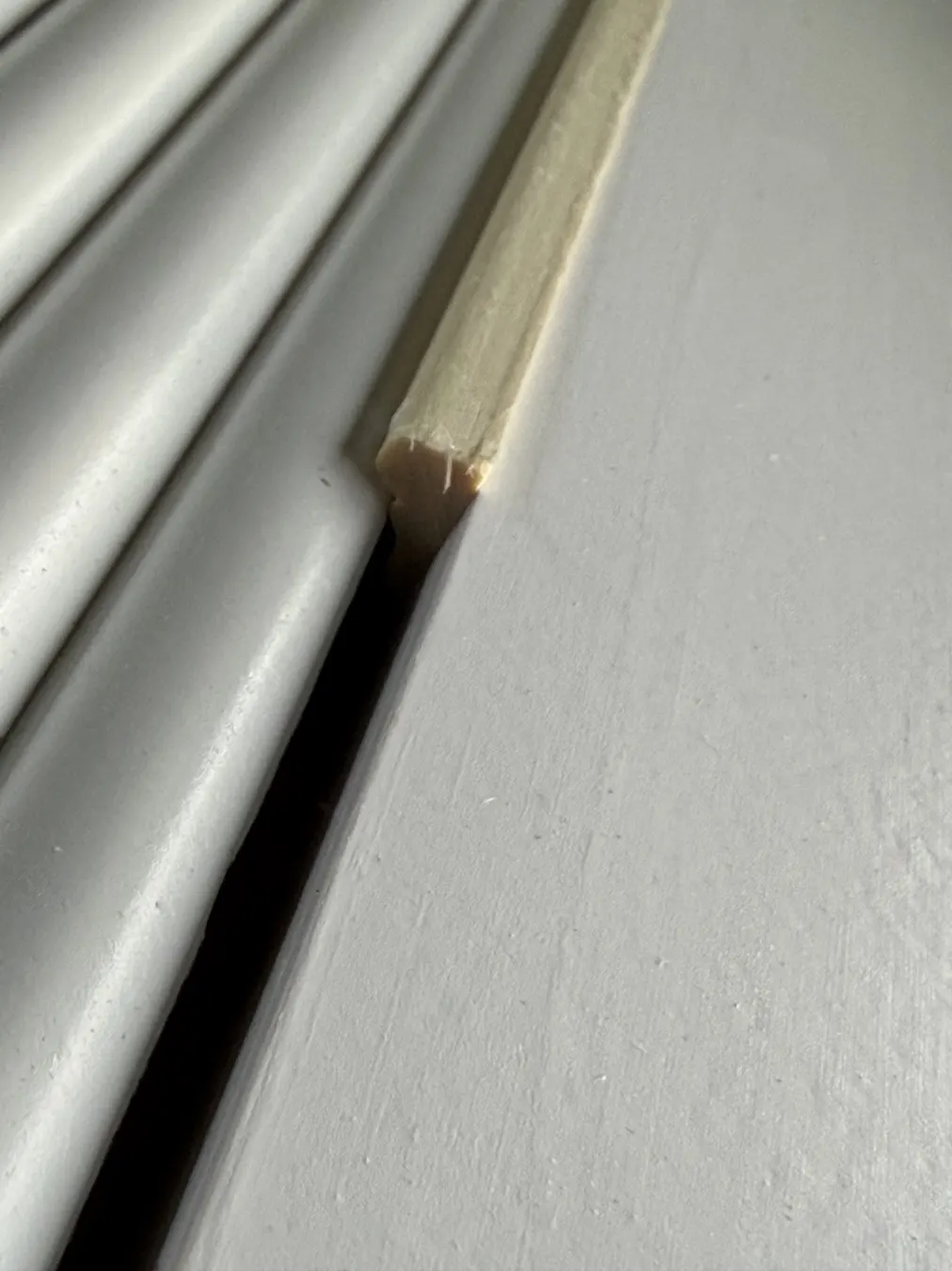 Narrow filler trim alongside the fluting