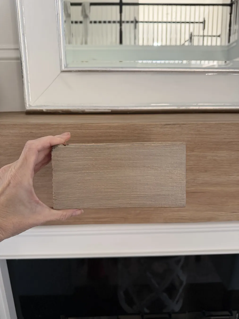 Testing a wood-tone sample against the mantel
