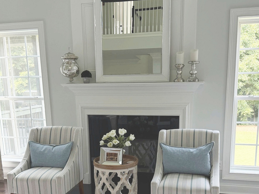 Before: the original white fireplace mantel with mirror and striped chairs in the family room