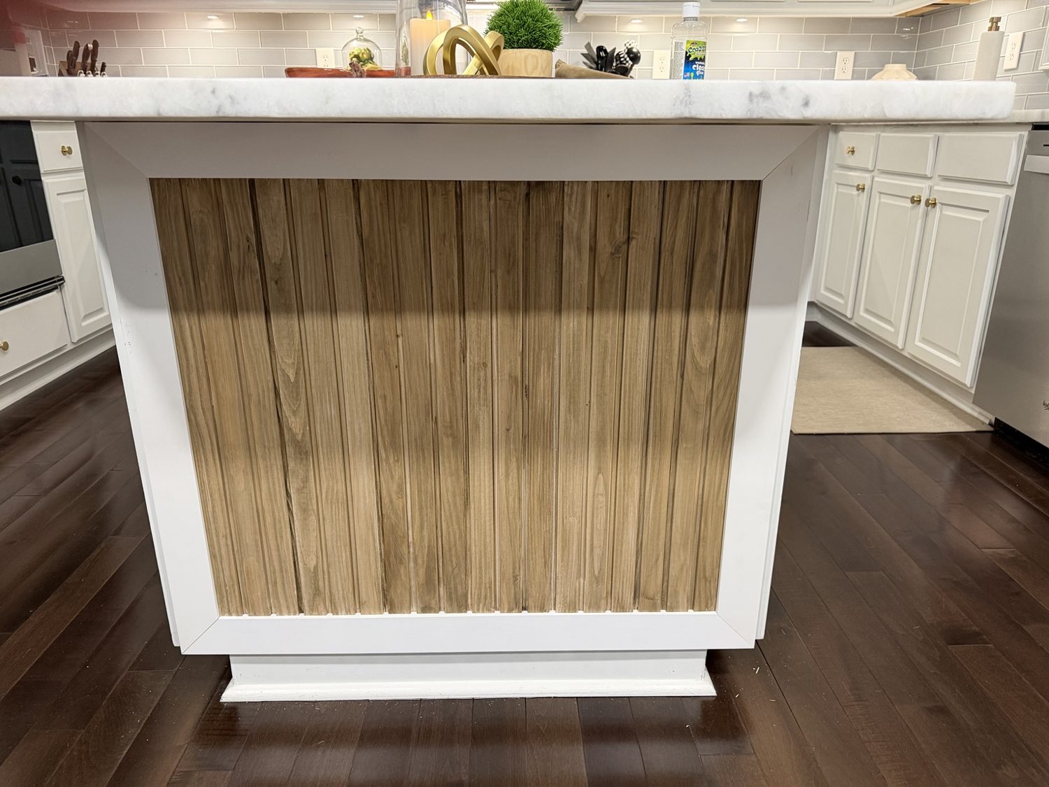 The finished island, with warm vertical pine boards framed by white trim.