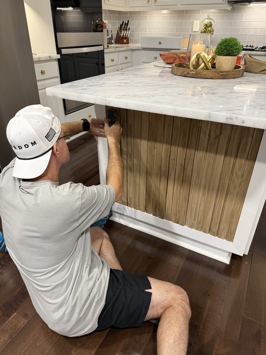 Installing the stained pine boards within the white 1×3 frame.